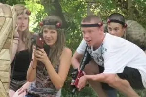 A group of people playing laser tag in the woods.
