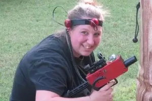 A woman holding a red laser tag tagger.