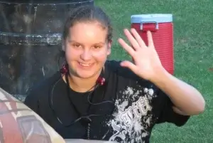 A girl is waving her hand at a laser tag party.