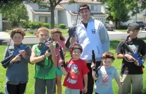 A group of kids with laser tag taggers posing for a picture.