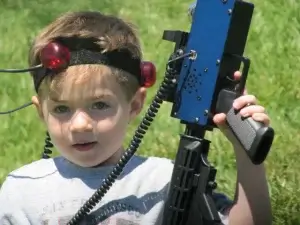 A young boy holding a blue laser tag tagger.