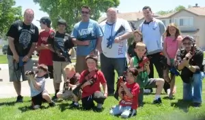 A group of children and adults posing for a photo at a laser tag party.