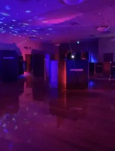 A room with purple lights for a laser tag night party.