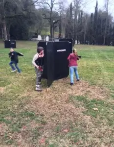 A group of people behind a barrier playing laser tag in a park.