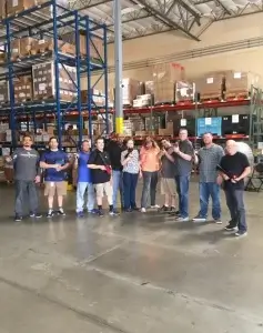 A group of people standing in a warehouse holding laser tag taggers.